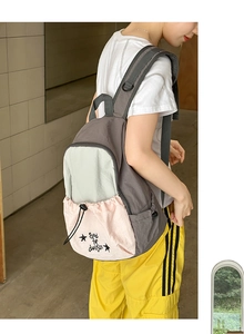 Detail view of the contrast color backpack with side pocket and printed graphic star motif