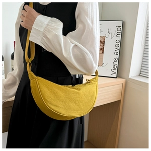 Detail of a bright yellow nylon crescent crossbody bag with adjustable wide shoulder strap