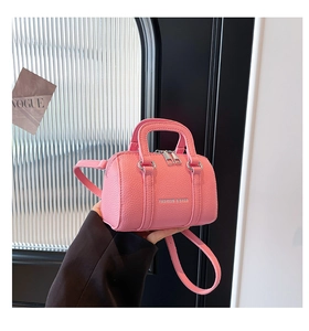 Détail du mini sac polochon rose avec texture litchi et bandoulière réglable chic