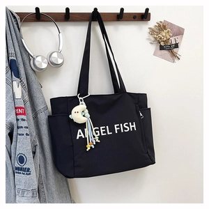 Détail d'un sac cabas en nylon noir avec imprimé et charmant pendentif lune blanche