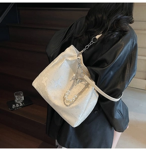 Détail du sac cabas en cuir verni blanc avec double chaîne en perles et métal
