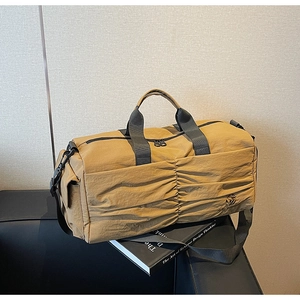 Detail of the khaki travel bag featuring unique horizontal pleated texture and sturdy black straps