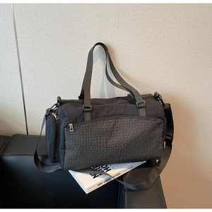 Detaillierte Nahaufnahme einer schwarzen Reisetasche mit grau karierter Reißverschlusstasche