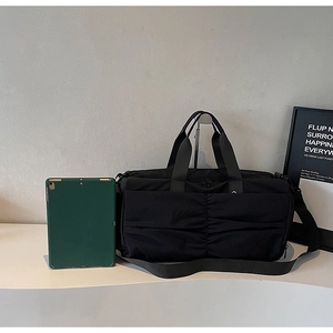 Detail view of large capacity travel bag with pleated front pocket and tablet compartment