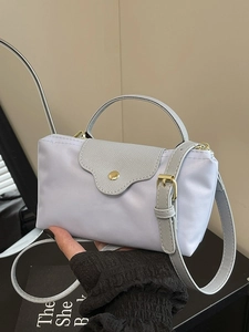Minimalist light blue nylon dumpling bag with leather handles and gold hardware accents