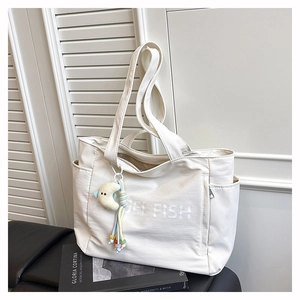 Détail du sac fourre-tout en nylon blanc avec texte Angel Fish et charme de lune doux