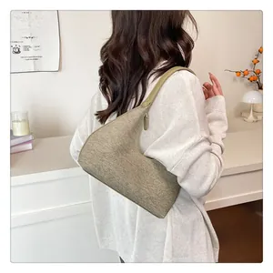 Close-up of khaki green hobo bag with woven texture on model in beige outfit