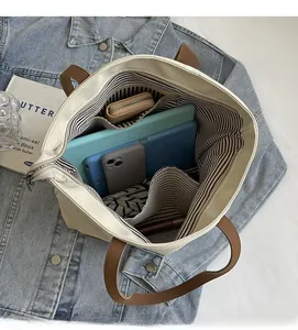 Interior view of canvas tote bag featuring striped lining and spacious compartments