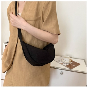 Close-up of black crescent nylon shoulder bag on model for daily casual styling