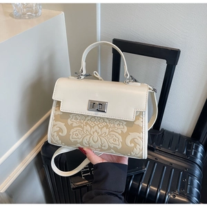 Detail of cream white bag showing floral embossed texture and silver twist lock