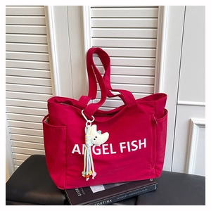 Détail du cabas en nylon rose avec lettrage Angel Fish blanc et pendentif en forme de lune