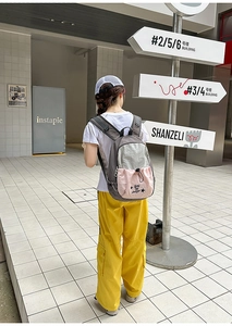 Detail view of water-resistant nylon backpack with gray, white, and pink color blocking