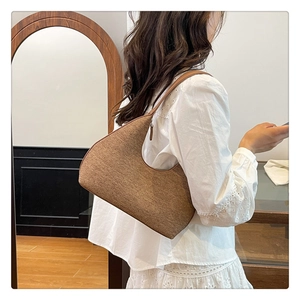 Detail showing the brown wool fabric texture and sleek leather strap of the hobo bag
