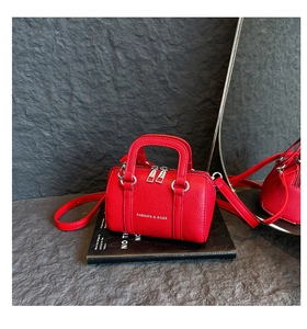 Détail du mini sac Boston en cuir grainé rouge avec texte argenté et double fermeture