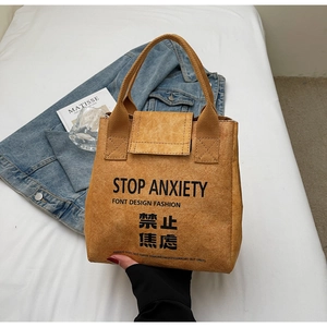 Close-up of waterproof Tyvek tote bag with 'STOP ANXIETY' print and pleated texture