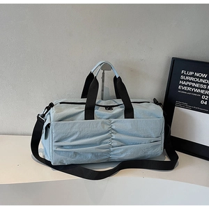Detail of light blue waterproof nylon travel bag with unique pleated front design and straps