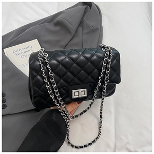 Detail of black quilted chain bag featuring silver hardware and a turn-lock closure