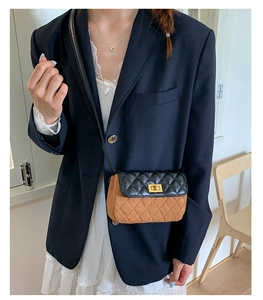 Close-up of quilted contrast crossbody bag with gold lock on a female model