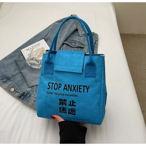 Detail of blue Tyvek waterproof tote bag with black Stop Anxiety typography print
