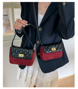 Detail of a quilted small flap bag with contrast color design and metal turn-lock