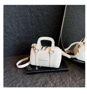 Détail du sac cylindre blanc à motif lychee avec texte fashion et bandoulière réglable