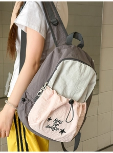 Detail of multi-color backpack showing drawstring pocket and star pattern in macro view