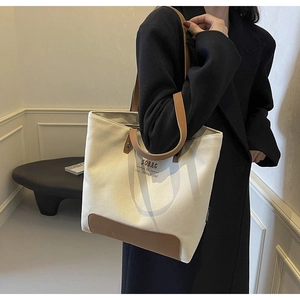 Detail of canvas tote bag with brown leather trim and SOBAG BE THE BETTER ONE printed text