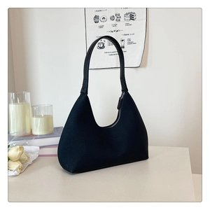 Close-up of minimalist black hobo bag with fine grain leather and smooth curved design