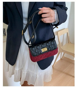 Detail of a quilted contrast crossbody bag with gold lock and velvet texture on a model