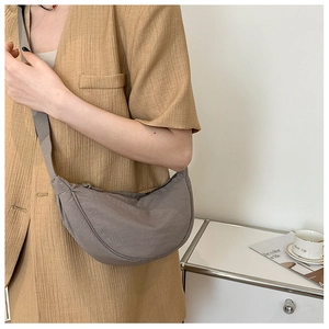 Detailed view of grey nylon crescent crossbody bag with adjustable wide shoulder strap