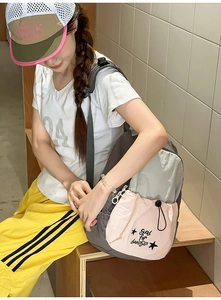 Detail of grey student backpack featuring a pink drawstring pocket and star pattern