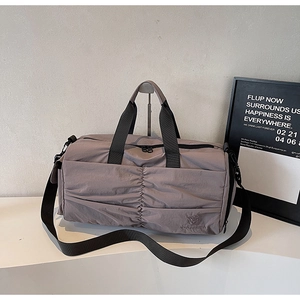 Close-up of waterproof textured fabric and embroidered logo on the dusty pink travel bag
