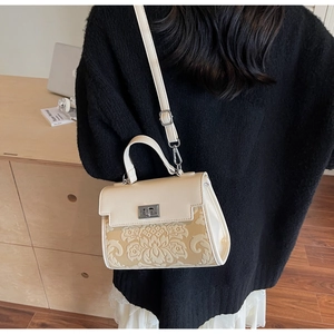 Close-up of vintage floral jacquard fabric and silver metal twist lock on the handbag