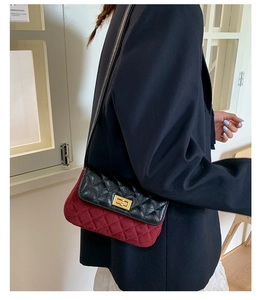 Detail of two-tone quilted leather crossbody bag with gold metal twist lock