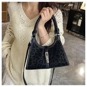 Detail of black leopard texture bucket bag with silver metal buckle and round handle