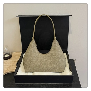 Detailed view of an olive green hobo bag on silk lining inside a black gift box