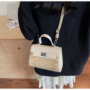 Detail view of cream white PU leather crossbody bag with yellow jacquard fabric and silver lock