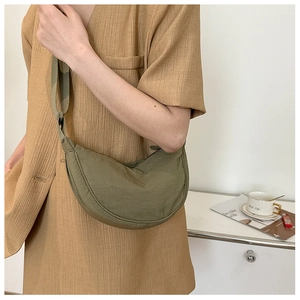 Close-up of olive green nylon half-moon crossbody bag with adjustable wide shoulder strap