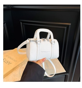 Gros plan du mini sac Boston blanc en cuir grainé avec des détails argentés