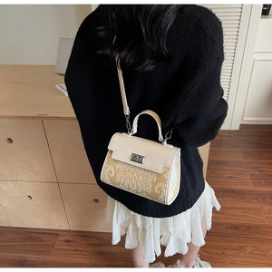 Detail of vintage cream white crossbody bag with gold jacquard floral fabric and metal clasp