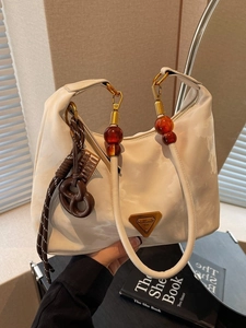 Chic cream dumpling bag with marble pattern, amber beads, and a metal triangle logo