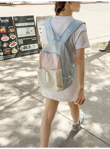 Detailed outdoor shot showing the three-color patchwork design of a large nylon backpack