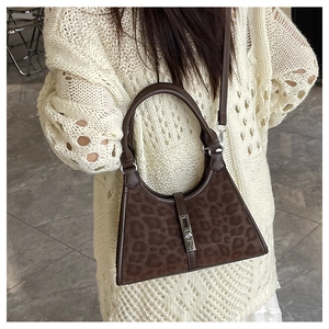 Detail of leopard print bucket bag with leather handle and silver metal buckle closure