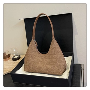 Brown textured hobo shoulder bag with metal zipper detail on a white dust bag inside a box