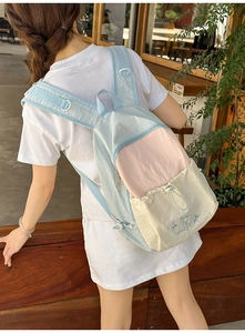 Outdoor shot of a student backpack in pastel blue and pink with star embroidery