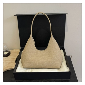 Beige textured hobo bag with fabric grain inside a black gift box and dust cloth