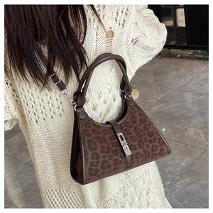 Detail of leopard print bucket bag featuring silver buckle and adjustable shoulder strap