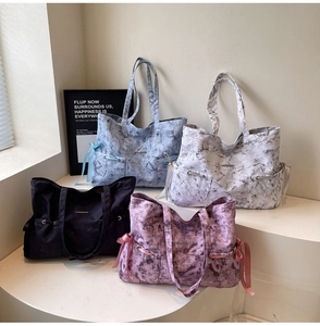 Détail de sacs fourre-tout avec texture marbrée et nœuds papillon en soie sur le côté