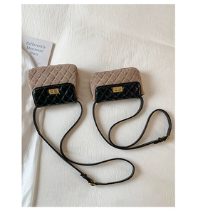 Close-up of quilted leather crossbody bag featuring a golden square twist lock buckle