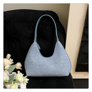 Detail view of light blue hobo bag with textured fabric and metallic top zipper